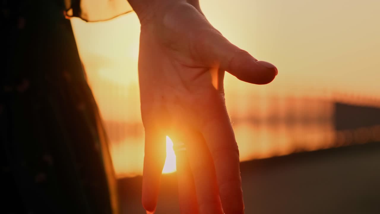 A Serene Moment: An Outstretched Hand Reaching for the Golden Horizon Beneath a Beautiful Sunset, Capturing the Essence of Peaceful Reflection and Elegance