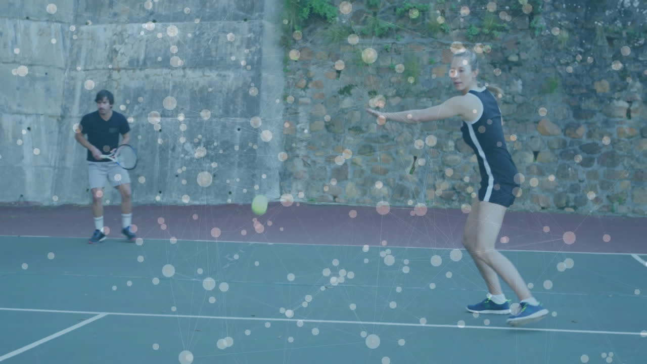 male holding racket and female swinging on outdoor tennis court, showing sports technology overlay