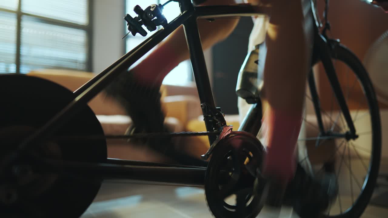 아시아 여성 자전거 타는. 그녀는 트레이너에서 자전거를 타고 집에서 운동하고 온라인 자전거 게임을합니다.