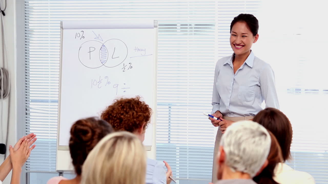 Busnesswomen applauding colleague after presentation