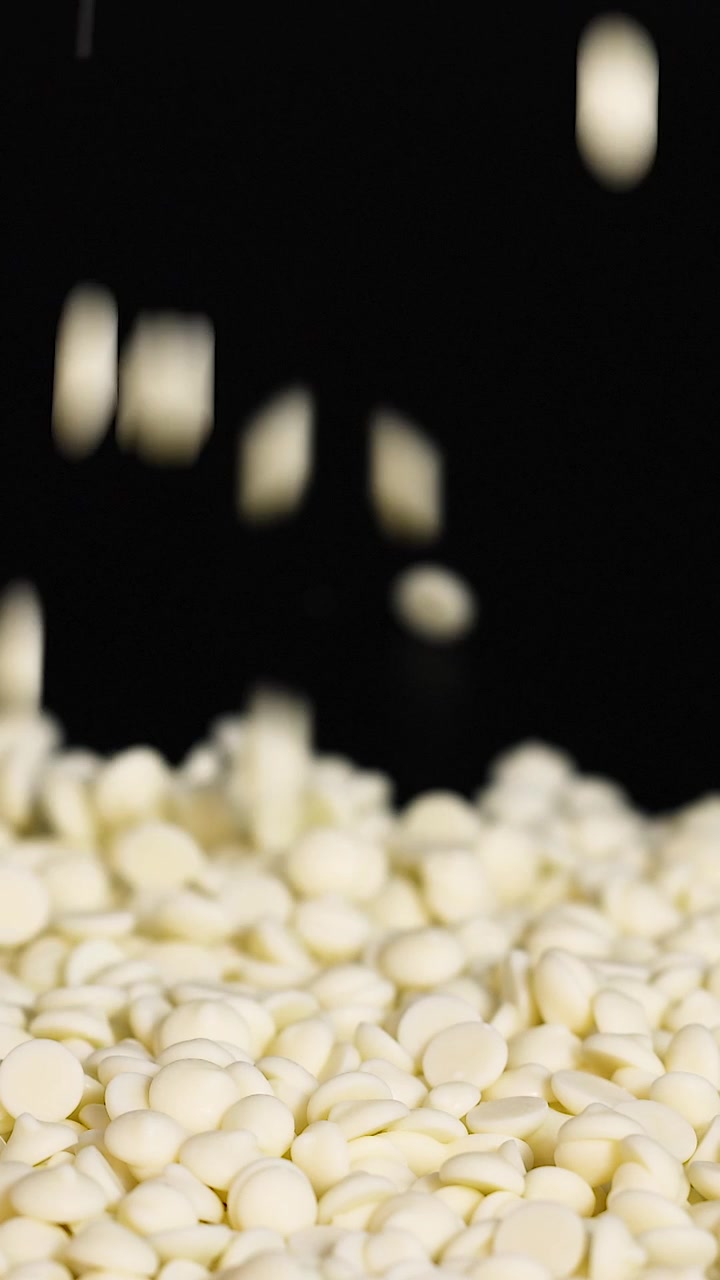 Gocce di cioccolato bianco che cadono su un mucchio