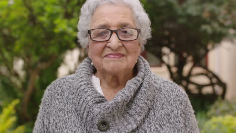 retrato de una anciana respirando sintiendo alivio en el jardín mirando a la cámara con gafas