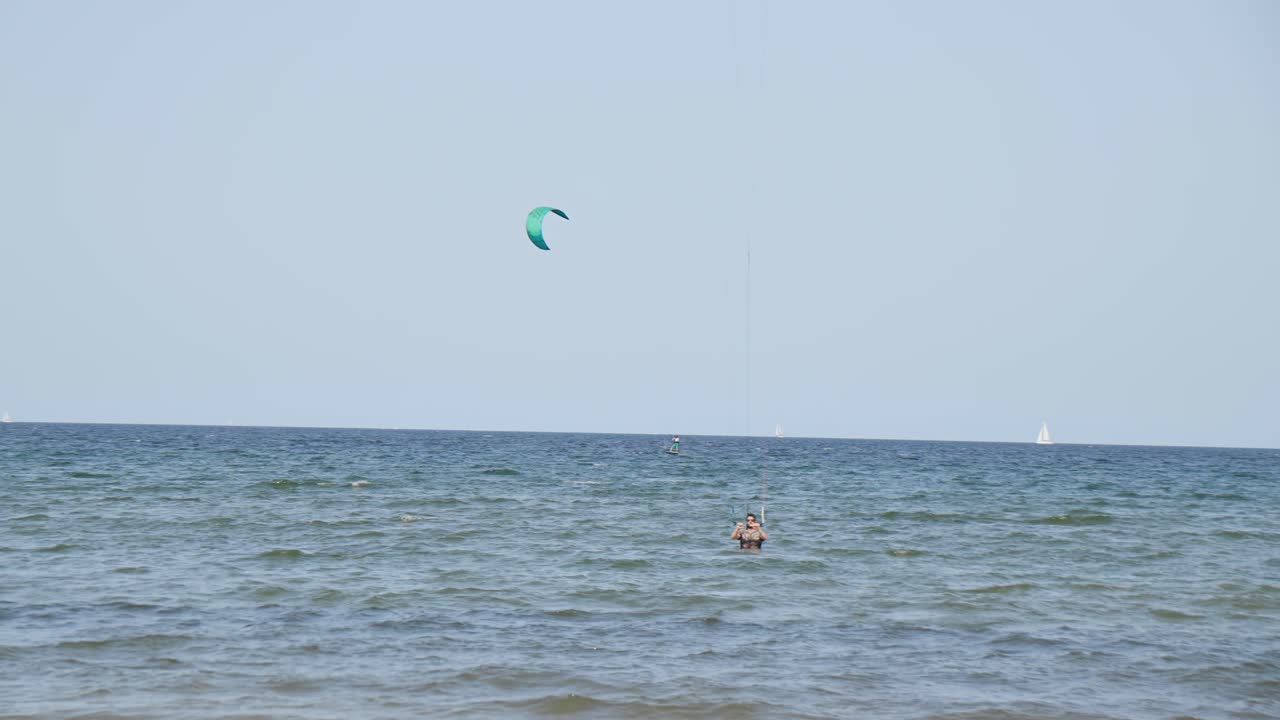 una persona está practicando kitesurf en agua azul cear con yates en la procedencia de mallorca islas baleares