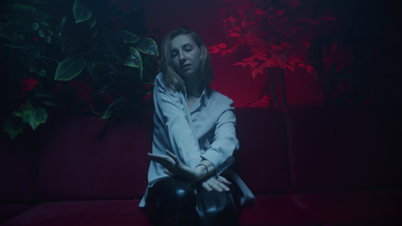 Woman Posing on Sofa in a Studio Setting