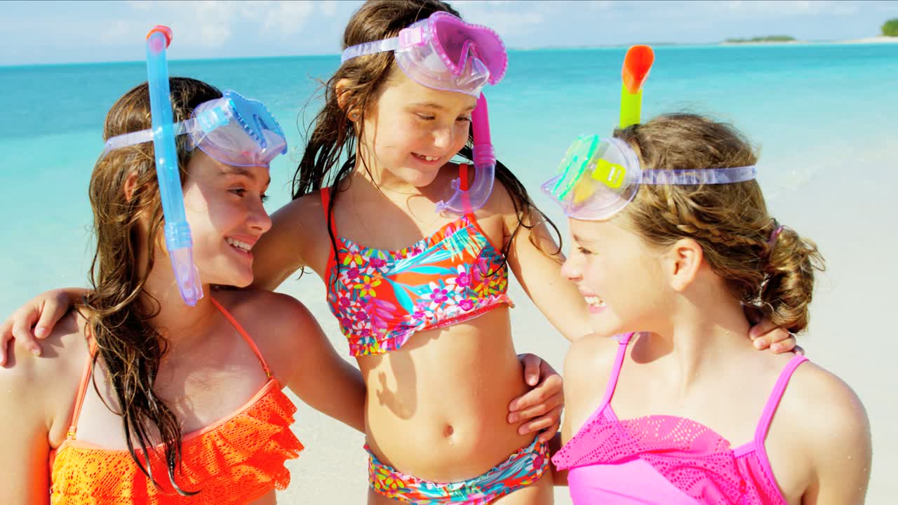 젊은 행복한 백인 소녀들이 카리브 해변에서 스노클링을 하고 있습니다.
