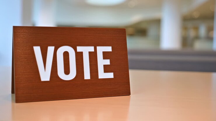 Cartello 'VOTA' in legno su un tavolo