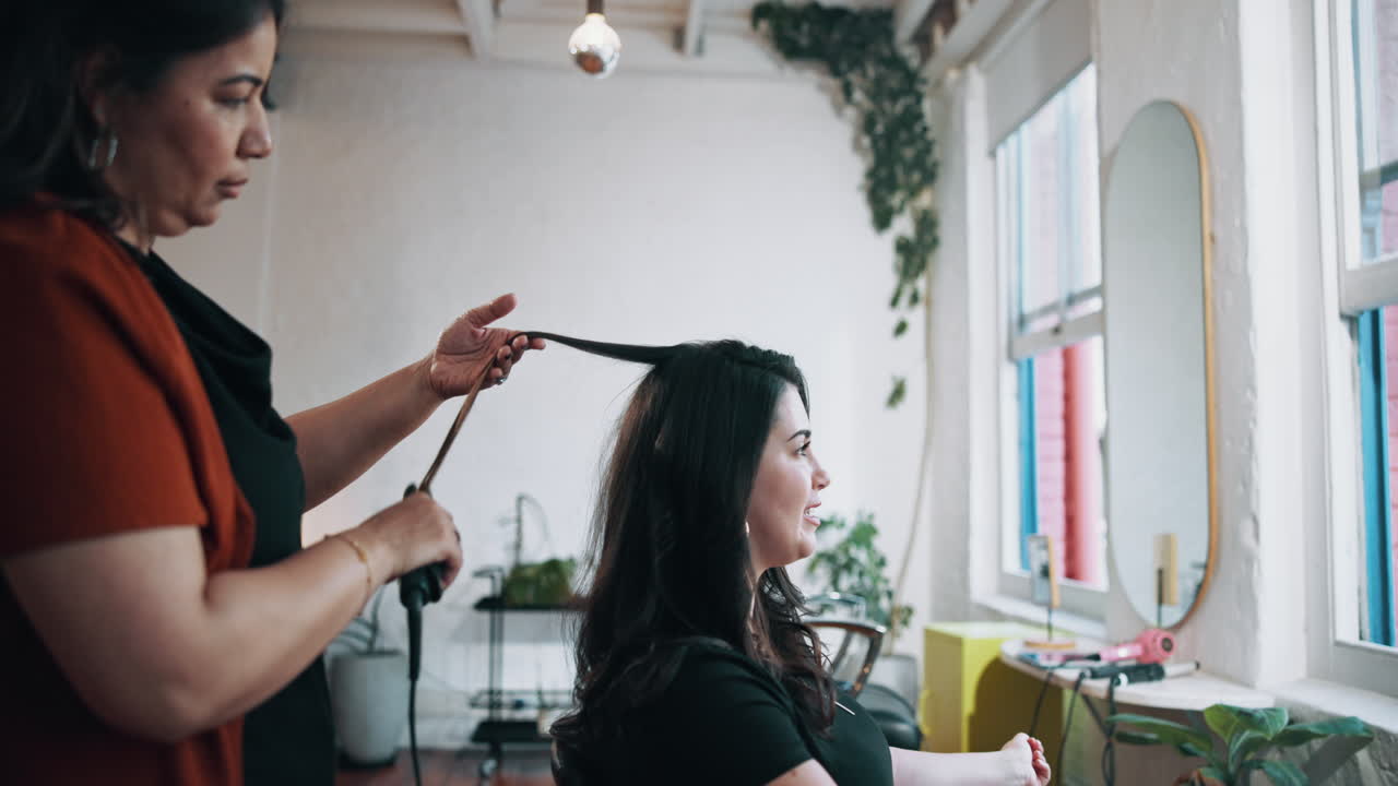 Hair Stylist Curling a Woman's Hair in a Modern Salon