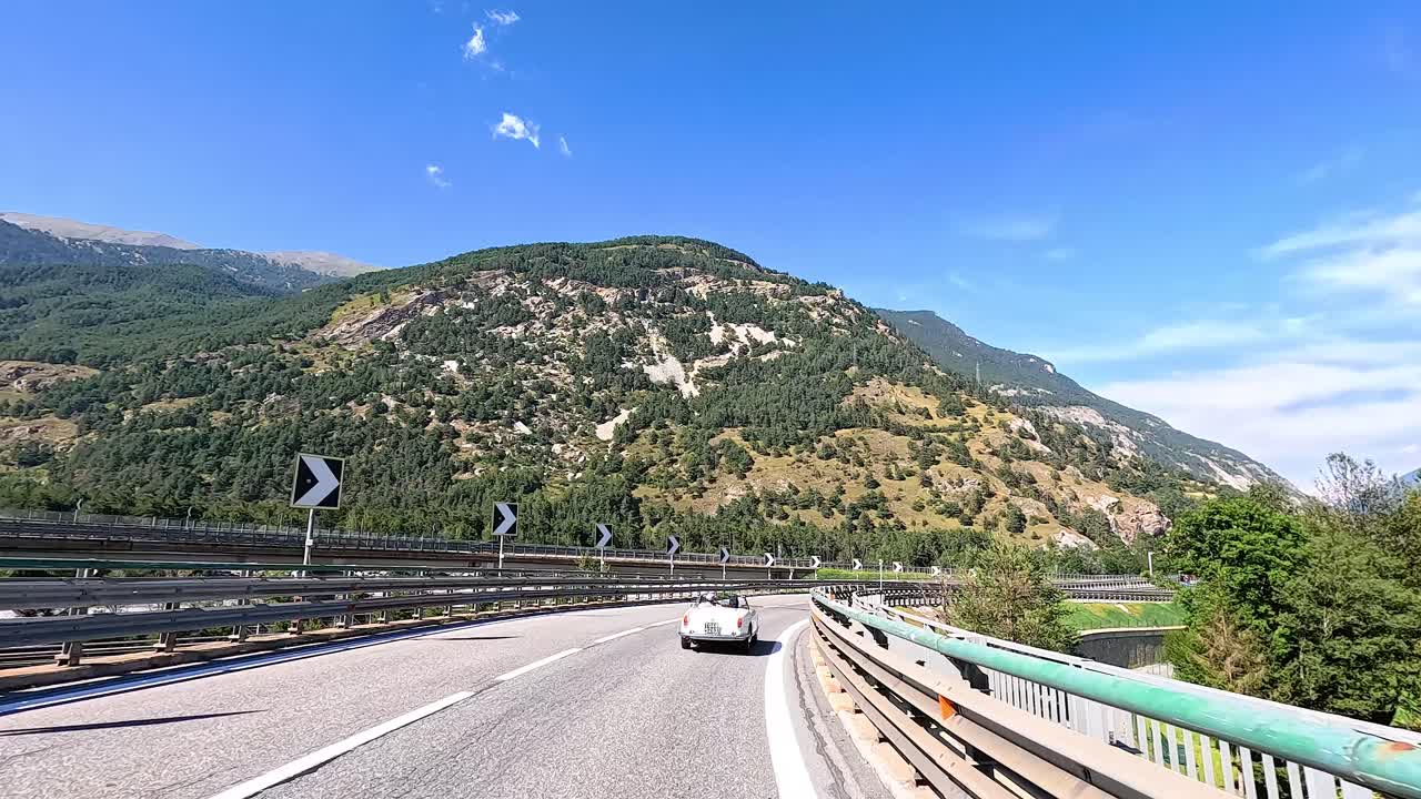 un coche conduce a través del terreno montañoso en piamonte, italia