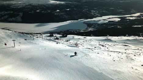 Snowy-slopes-with-nice-lighting-through-the-clouds-showing-a-cabinlift-station