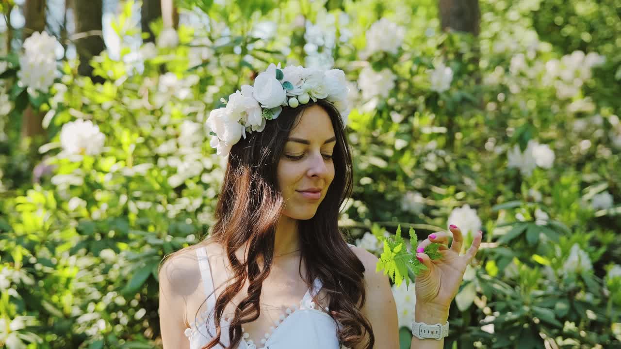 Flower-Crowned Woman Holds Fern Leaf in Blooming Forest – Slow Motion Latvia