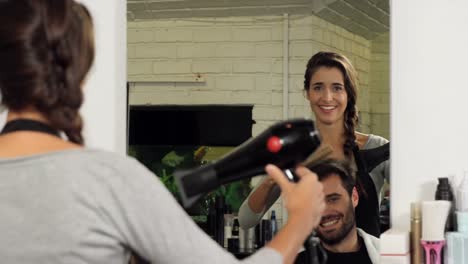 female hairdresser blow drying her client hair