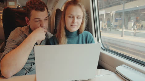 people talk on business using laptop in train