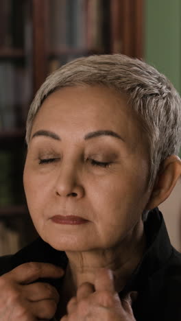mujer mayor ajustando chaqueta en una biblioteca