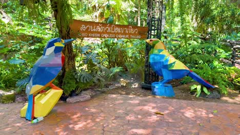 vibrant parrot sculptures in lush zoo setting