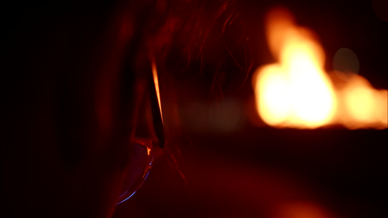Person's Profile Illuminated by Warm, Blurred Fire at Night