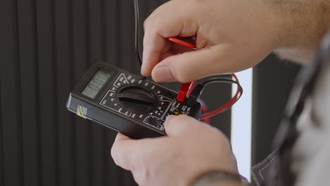 primer plano del dispositivo de un electricista de trabajo que comprueba la presencia de tensión en la red