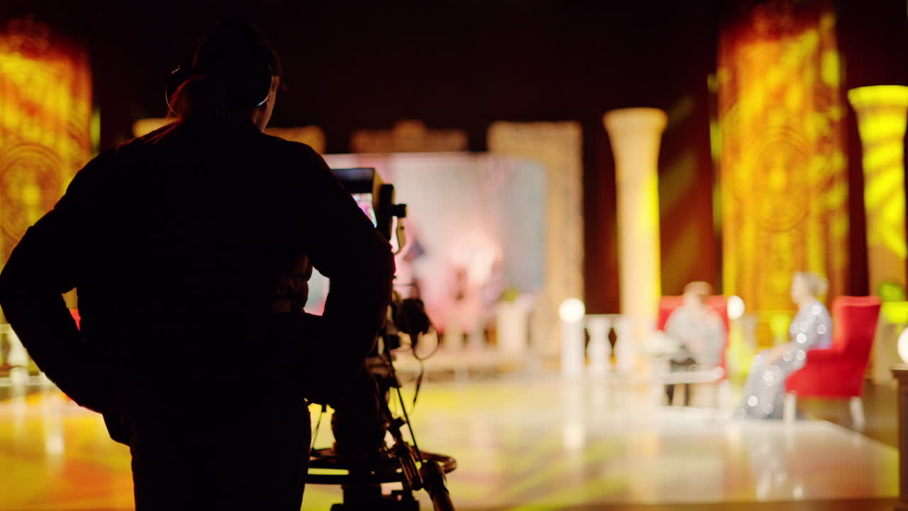 Man filming with professional camera on the backstage of a TV set