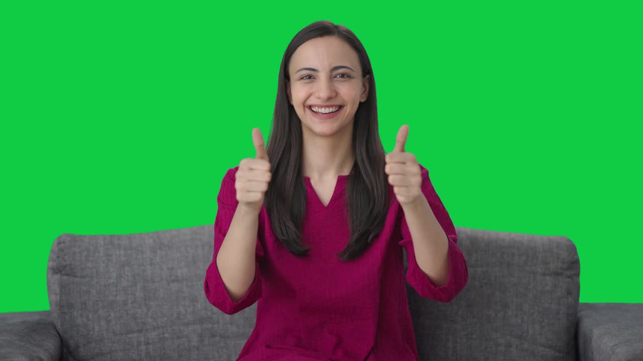 mujer india feliz mostrando los pulgares en la pantalla verde