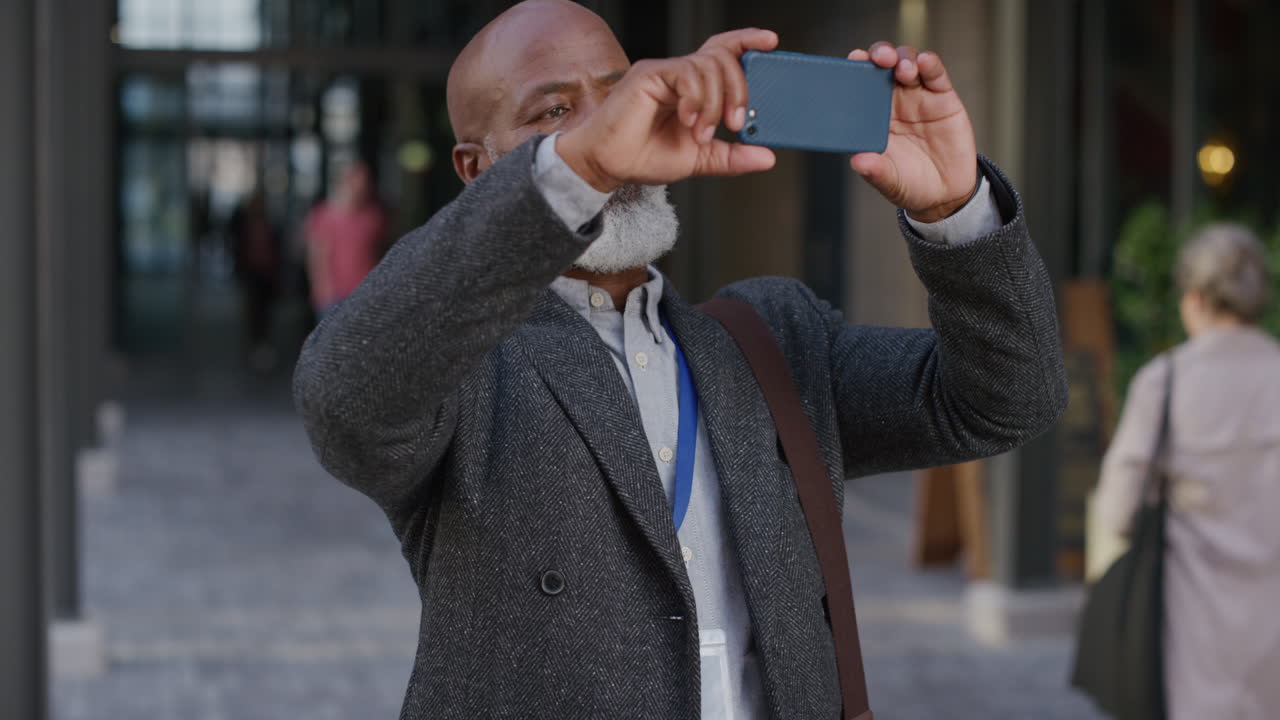 portrait black middle aged businessman using smartphone taking photos in city enjoying photographing travel experience on mobile phone camera slow motion