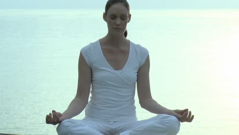 Frau-Macht-Yoga-Mit-Dem-Meer-Im-Hintergrund