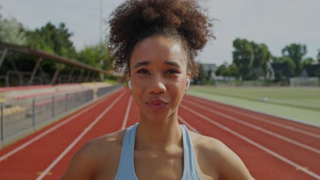 mujer sonriente en la pista de atletismo