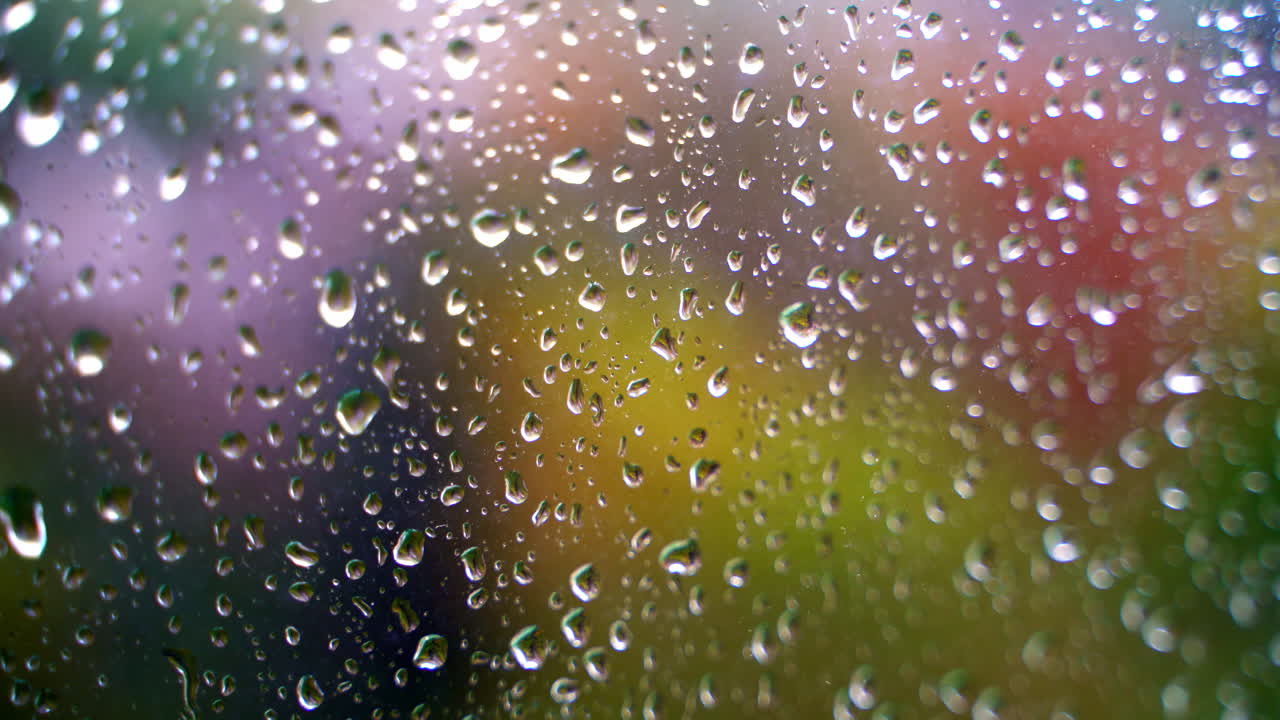 Water drops on glass window. Texture water drops on the blur colorful background. Water droplets on glass. Close-up.