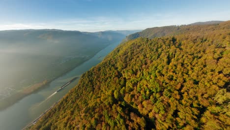 Fpv-Alto-Sobre-Las-Hermosas-Colinas-De-Wachau,-Girando-Lentamente-Hacia-Un-Barco-En-El-Pacífico-Río-Danubio,-Brillando-Bajo-El-Sol-De-Otoño