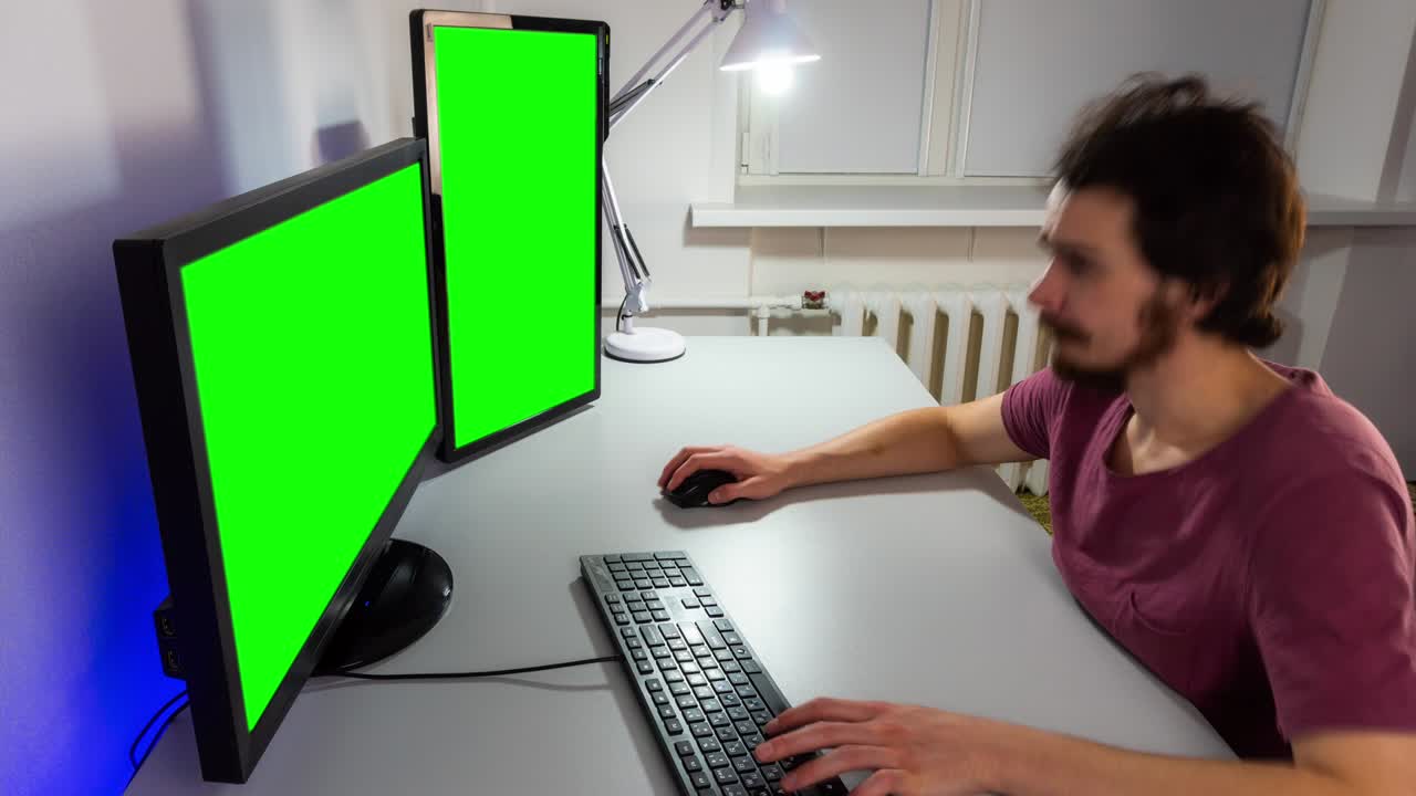 lapso de tiempo de un programador trabajando frente a dos monitores con pantalla verde y escribiendo en el teclado