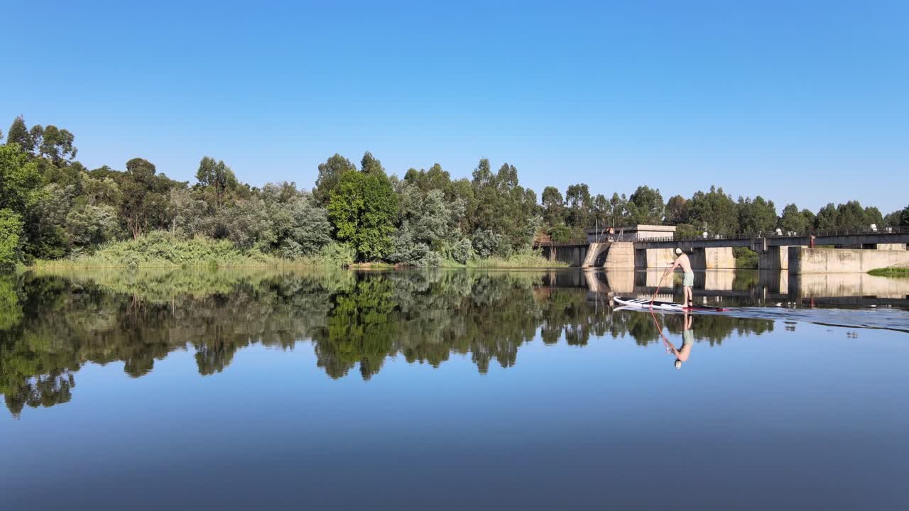 imágenes aéreas de un hombre remando en una presa.