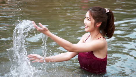 美麗的女人是放鬆和愉快的 玩水噴水流在河流和潮湿的夏天假期時間