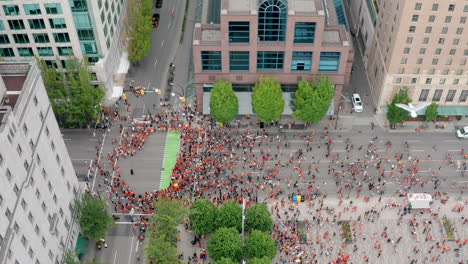 rising drone view of a political rally march in downtown vancouver canada