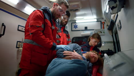 mixed race medical team giving first aid help in ambulance car