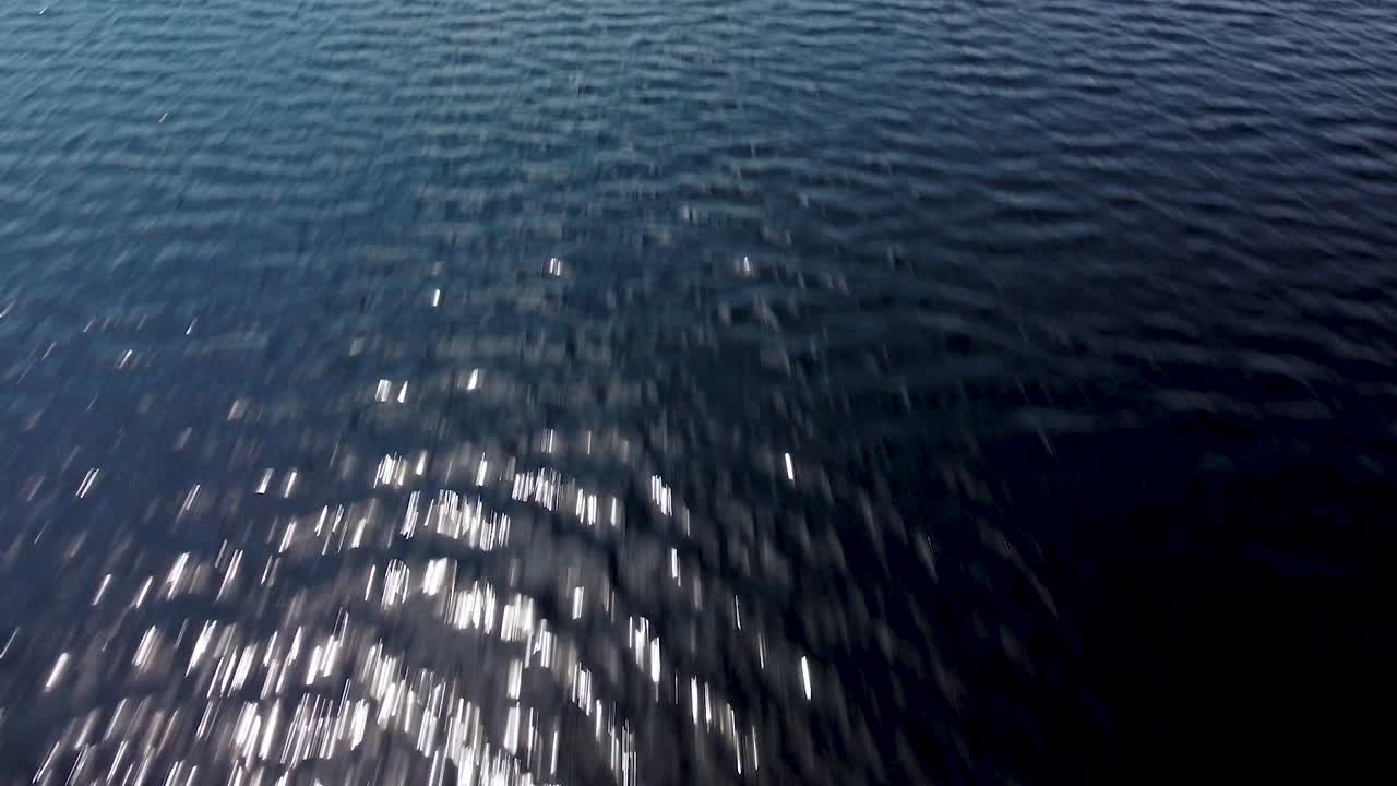 sobrevuelo aéreo sobre una superficie tranquila del lago pape en un día de verano tranquilo, disparo de drone de gran ángulo moviéndose hacia adelante, la cámara se inclina hacia arriba