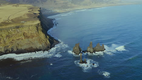 waves crashing at reynisdrangar basalt sea stacks at daytime near reynisfjara beach in vik, iceland