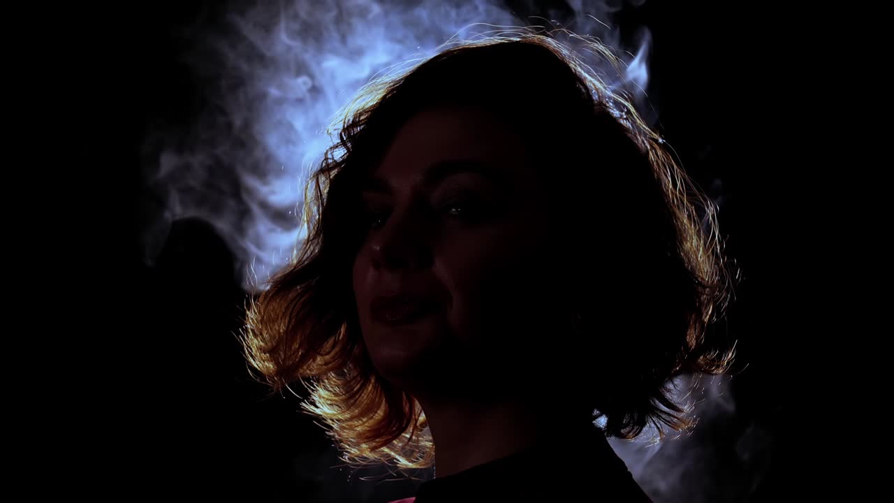 검은색에 카메라를 위해 포즈를 꾸미는 곱슬머리 한 여자