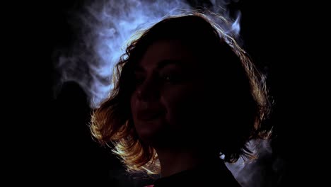 languid woman with curly hair poses for camera on black