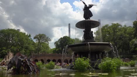 closeup view of a water fountain and sculpture against a background of new york city skyline