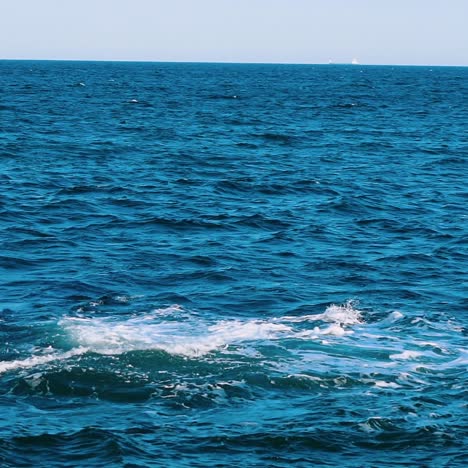 amazing water background. waves swaying on the sea water. beautiful blue water waves with white foam crashing on the dock. slow motion.