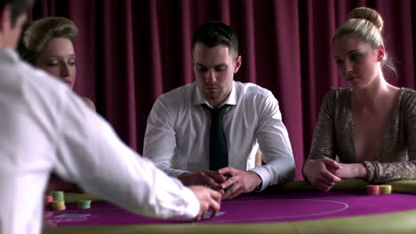 focused dealer dealing cards at the poker table in the casino