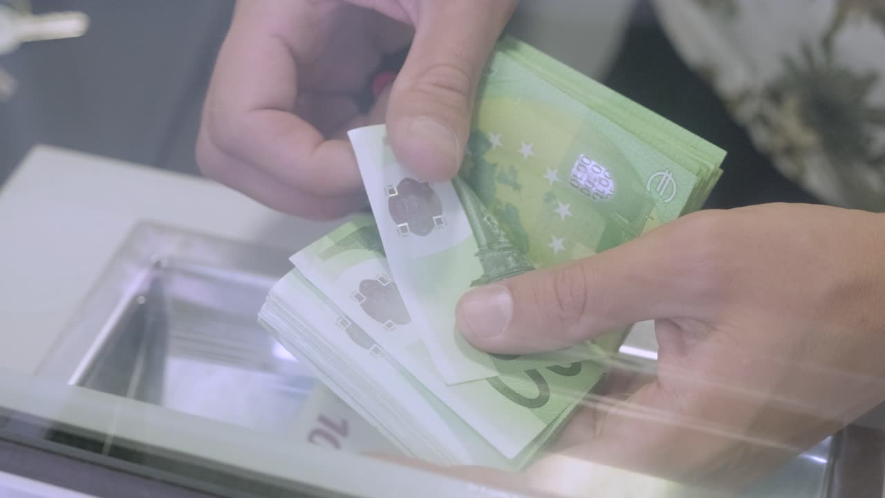 색 배경으로 돈을 세는 손.