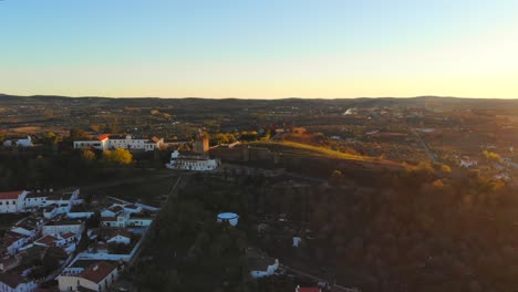 Noch-Eine-Drohnenaufnahme-Eines-Turms-Auf-Einem-Hügel-Im-Sonnenuntergang