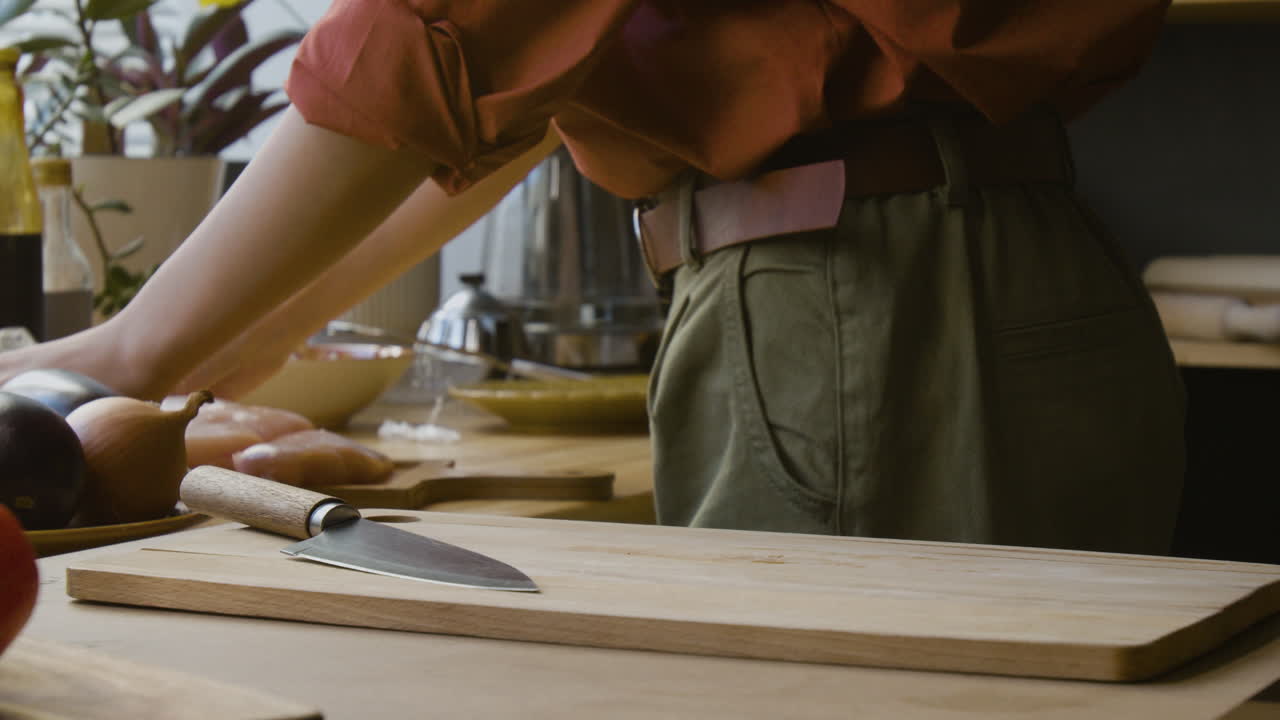 mujer cocinando pollo en la cocina