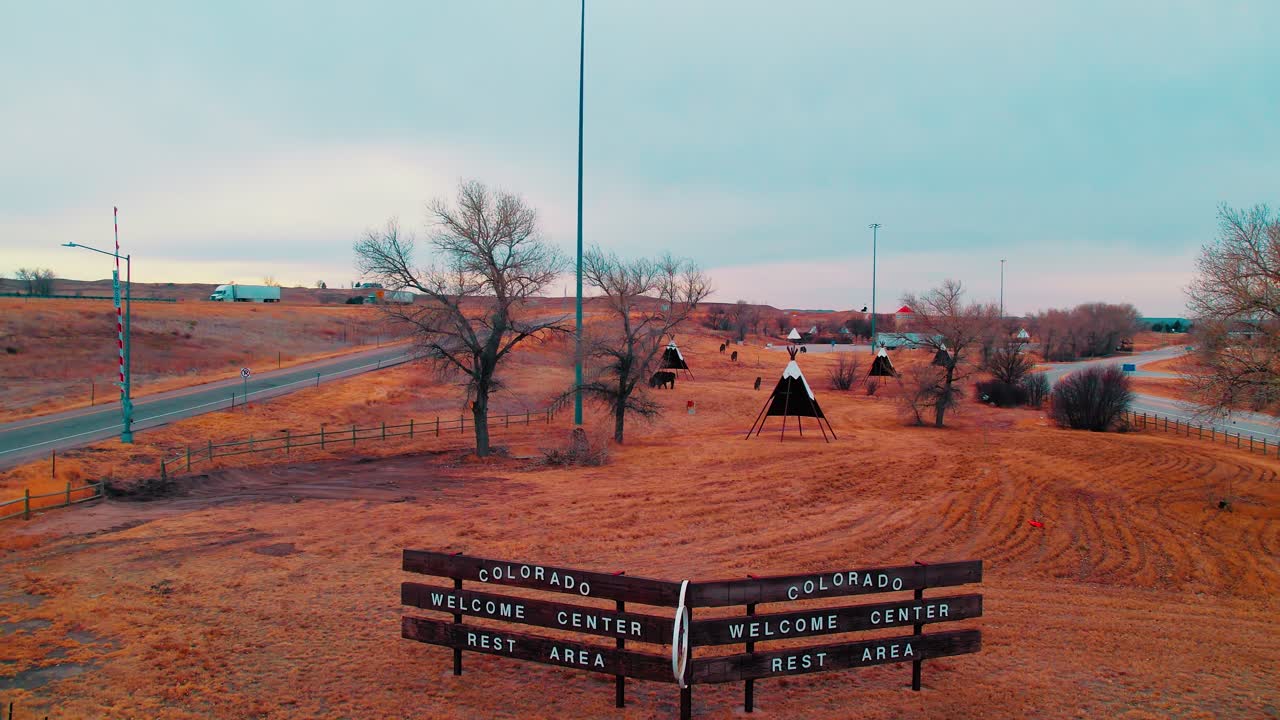 Colorado’s welcome center rest area, featuring teepee displays with passing trucks on I-80 highway