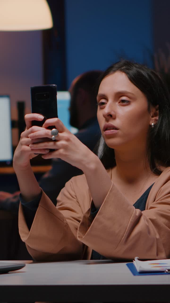 Vertical video Overworked executive manager holding phone texting marketing ideas