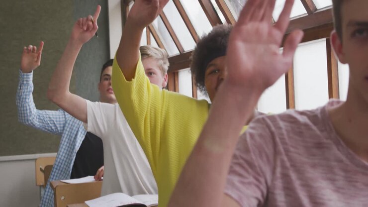 Students raising their hands in class