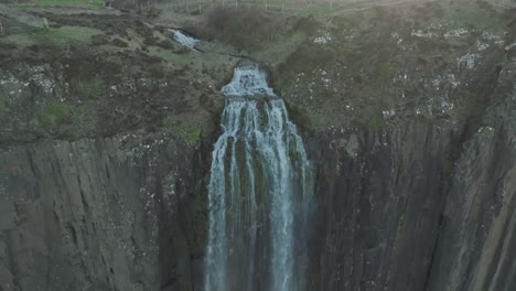 Aerial-establishing-shot-of-the-beautiful-Kilt-Rock-Waterfall-at-sunset