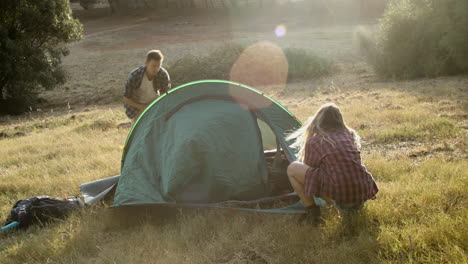 un par de excursionistas parando para acampar en el césped