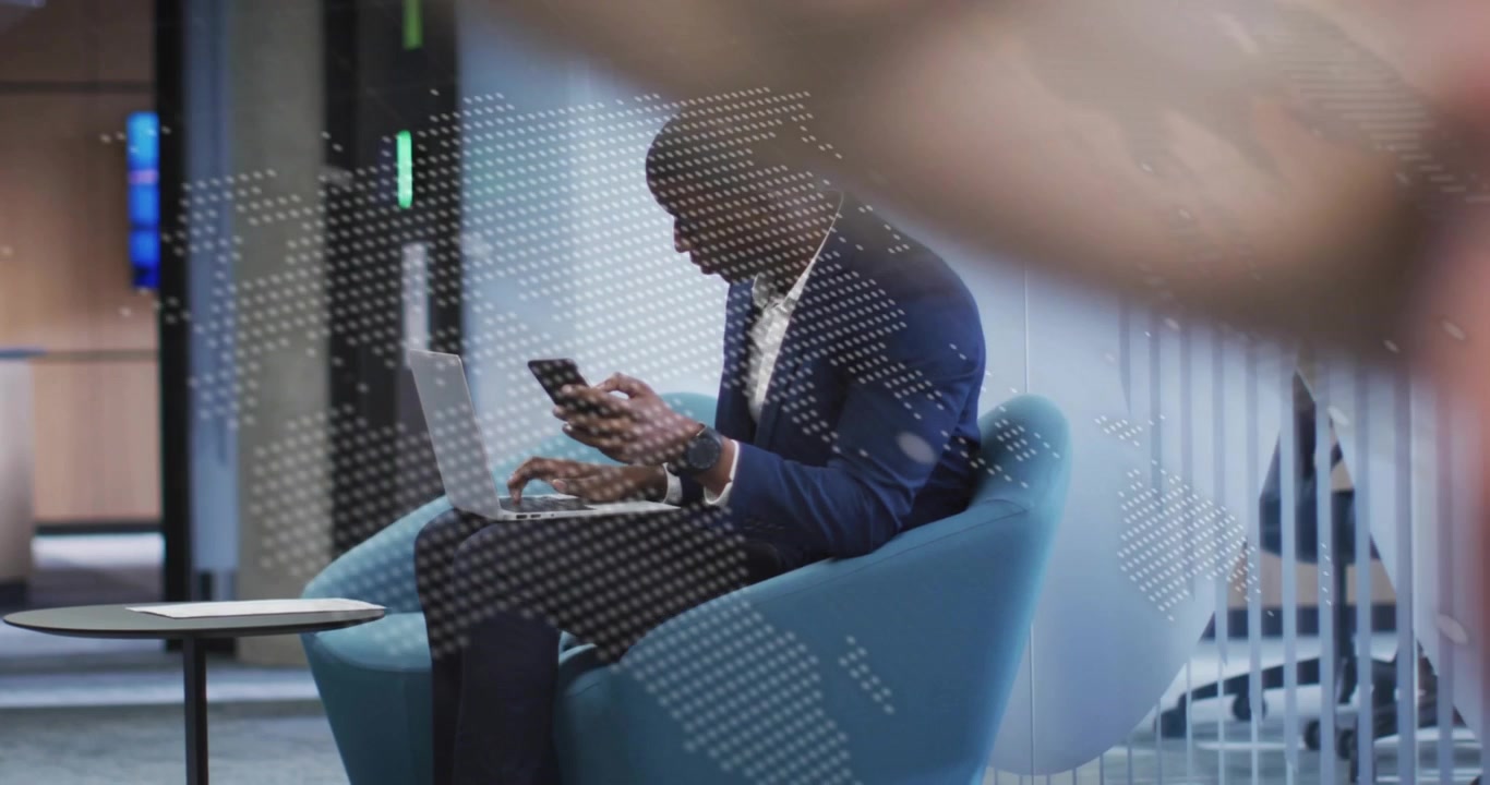 Typing and checking man in blazer on laptop, smartphone in lounge glass map passerby obscuring view