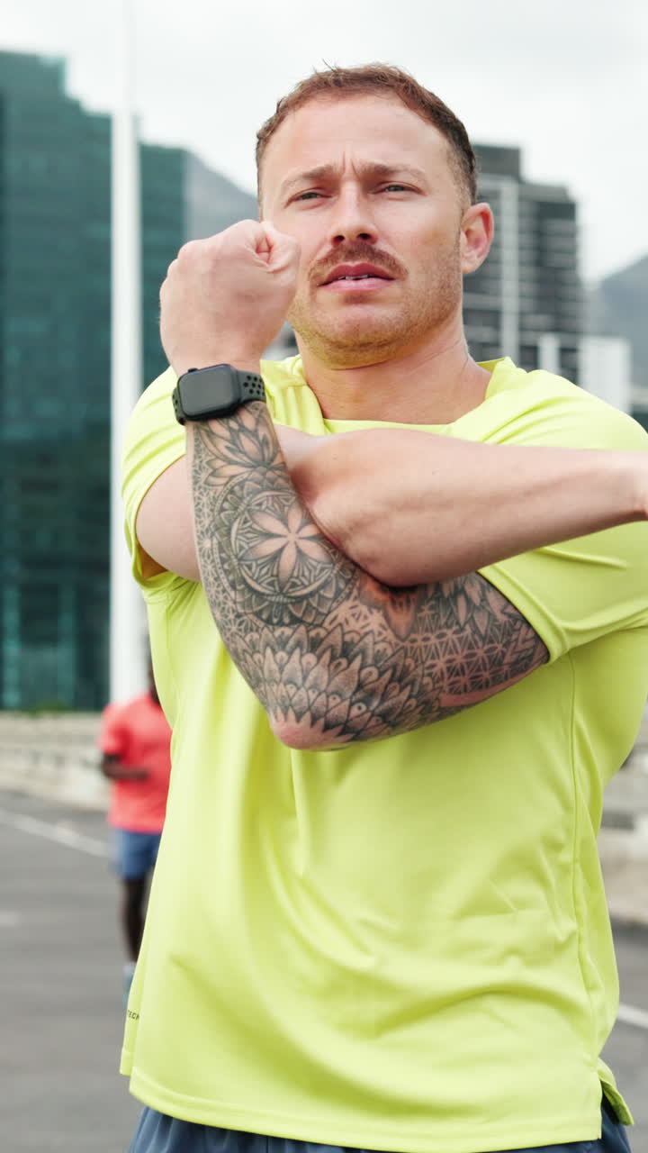 Homem com Tatuagens Alongando o Braço em Ambiente Urbano