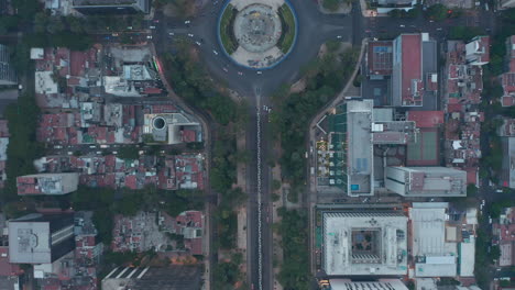 Vista-Aérea-De-Pájaros-Arriba-Abajo-Vista-Panorámica-Siguiendo-La-Calle-Con-Cruce-Circular-En-El-ángel-Del-Monumento-A-La-Independencia.-Ciudad-De-México,-México.